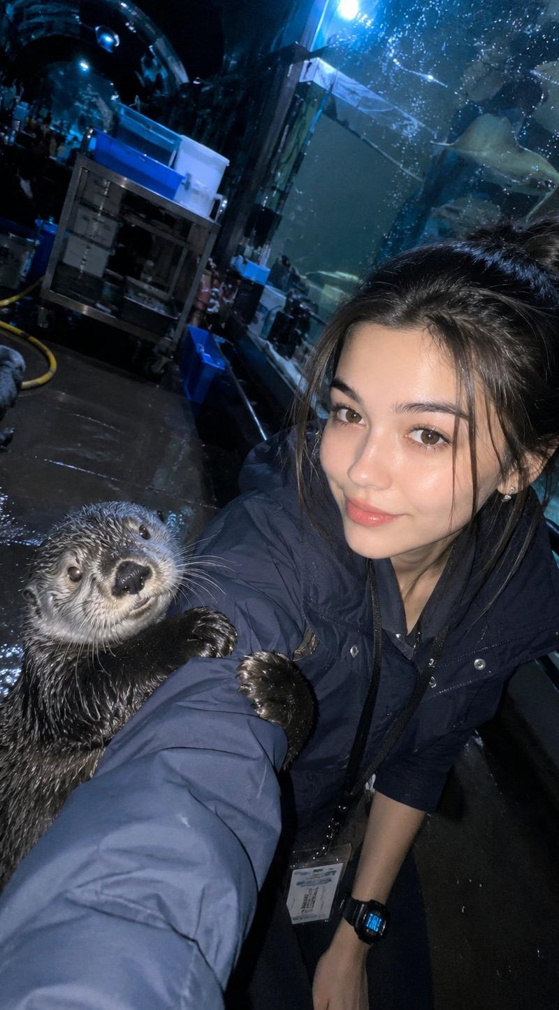 昏暗水族馆隧道饲养员与海獭自拍