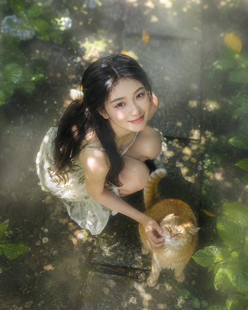 俯拍丁达尔效应花园少女与橘猫