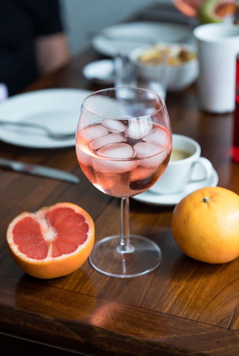 iPhone snapshot, casual home photo, pink gin on wooden table, messy table, glass