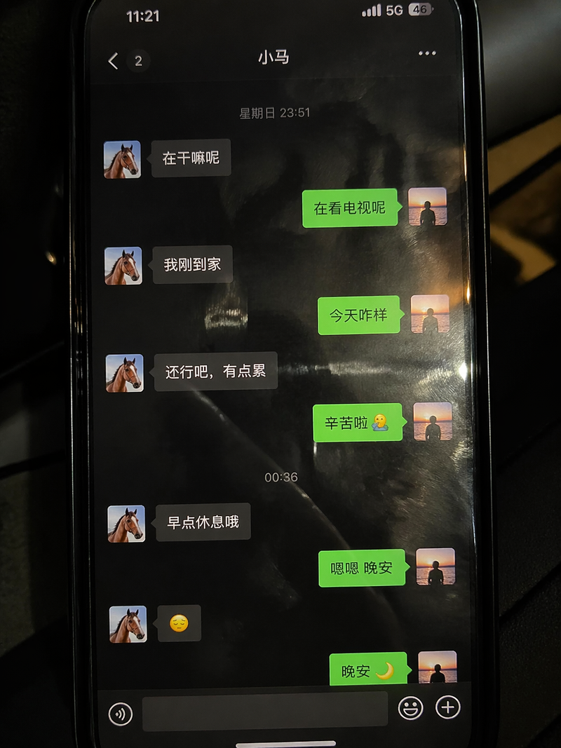 一张拍摄手机屏幕的照片,手机里面是我和小马之间的微信聊天记录界面,手机屏幕有反光,还有指纹油污,这张照片就像是手机随手拍的一样