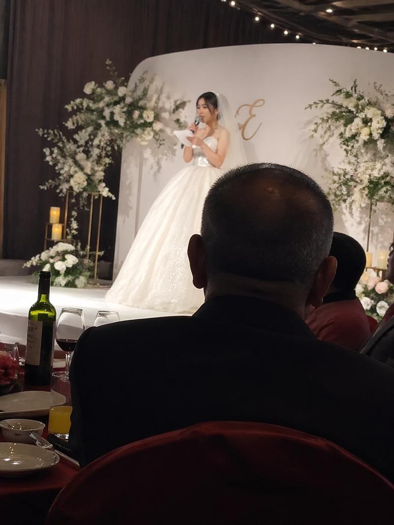 iphone 抓拍瞬间，结婚时新娘在台上说话，爸爸坐在下面婚桌吃饭的背影