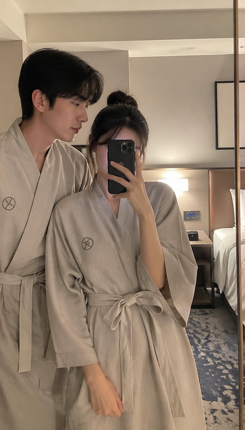 韩国酒店房间内,情侣穿着浴衣,站在镜子前自拍