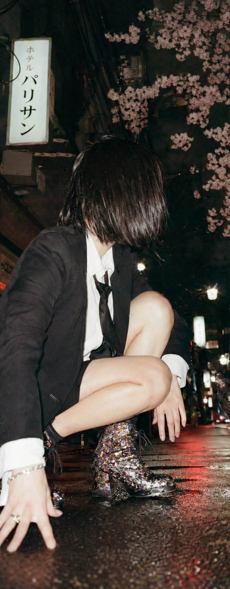 A cinematic candid night street photo in Tokyo shot from an extremely low ground