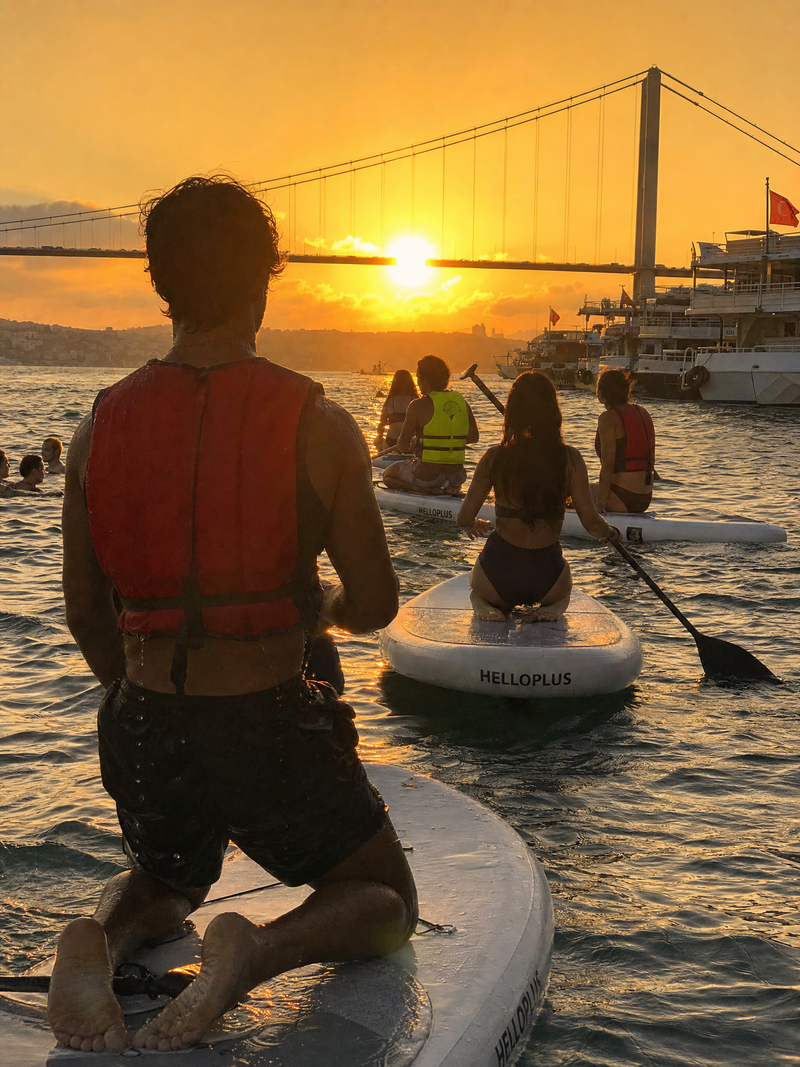 ```json { "subject": { "description": "Multiple figures paddleboarding on a rive