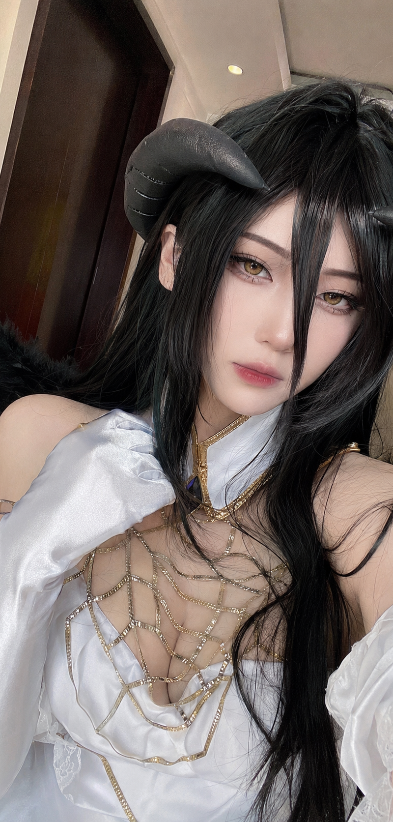 生成一张竖屏 9:16 的近距离手机自拍感 cosplay 妆照:一位成年女性扮演雅儿贝德 Albedo,保留真实前置手机自拍的亲密距离和轻微广角压缩感。人物脸