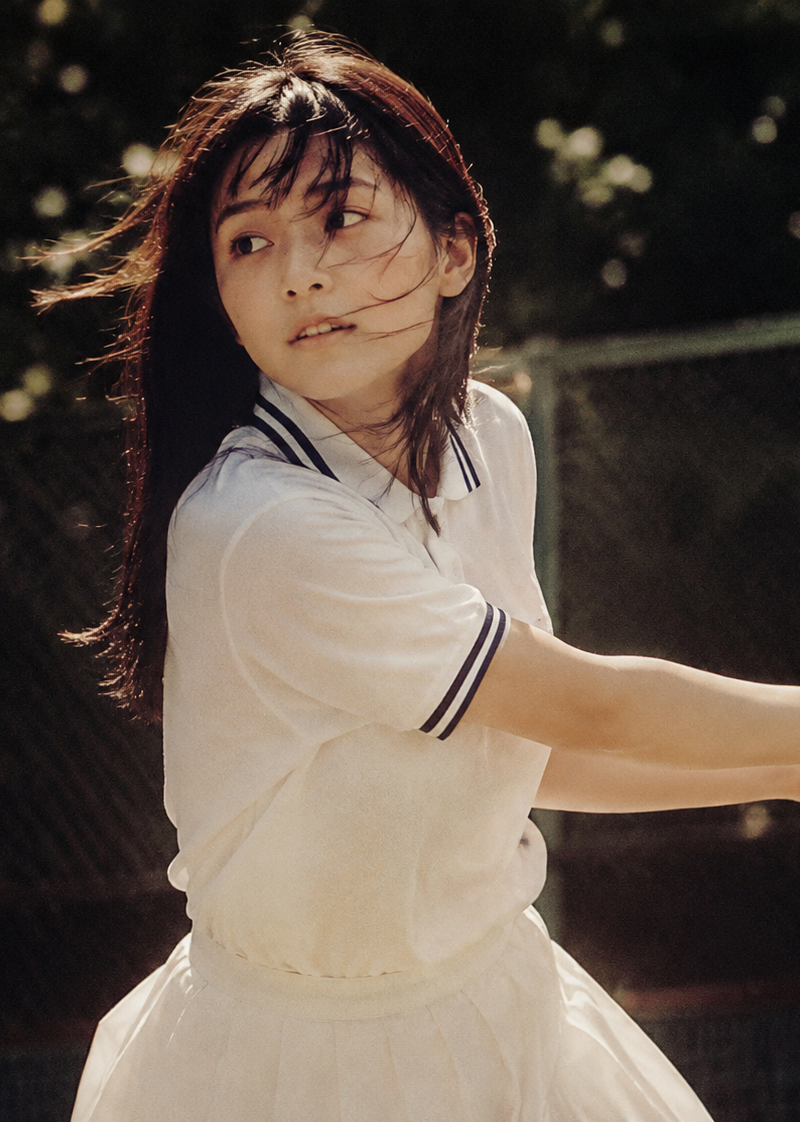 Cinematic middle shot of a Japanese teenage girl in tennis uniform, captured can