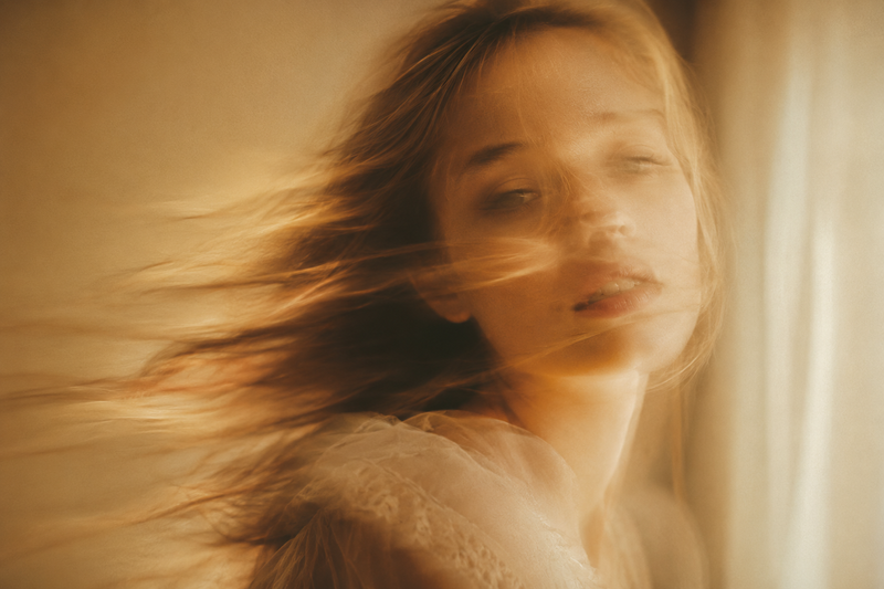 A soft-focus, cinematic portrait of a young woman with delicate facial features 