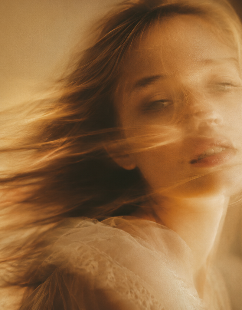 A soft-focus, cinematic portrait of a young woman with delicate facial features