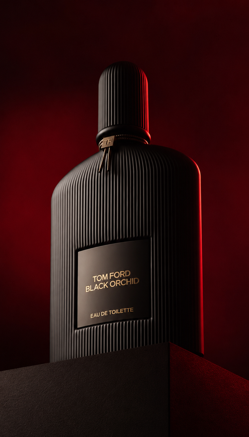 Low angle luxury product photography of a black ribbed glass perfume bottle plac