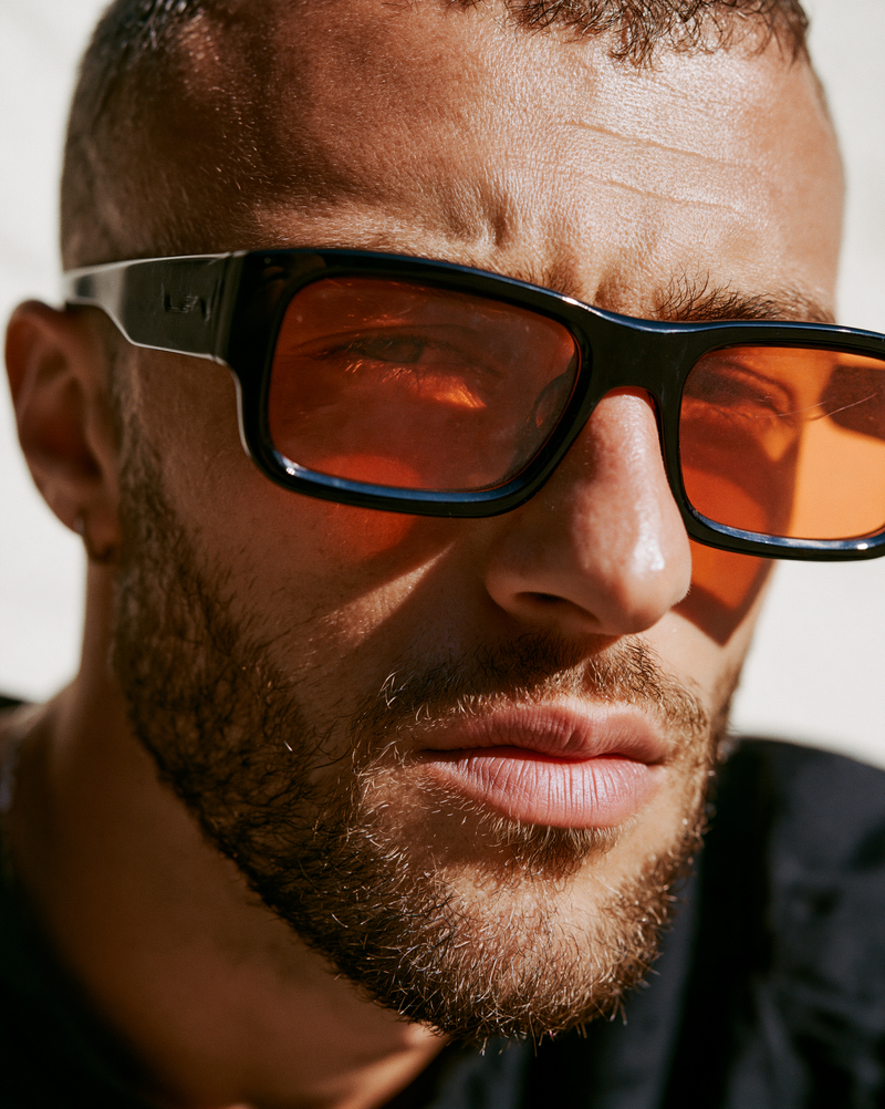 close-up fashion editorial photography of male model wearing vintage sunglasses,