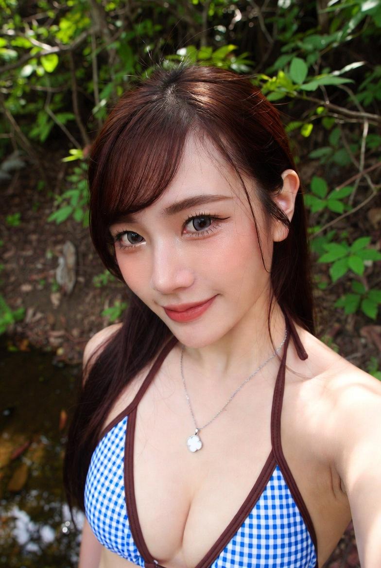Subject: A young adult woman in a close, upper-body shot, taking a selfie with a